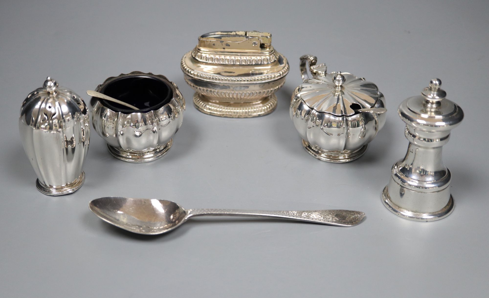 A peppermill, a three piece condiment set, a Victorian christening spoon and a plated lighter